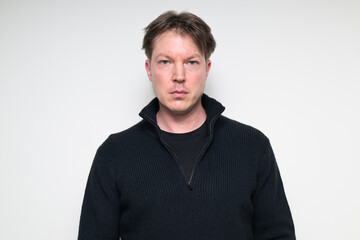 Fototapeta premium Portrait of Scandinavian mid adult man in black sweater against white background