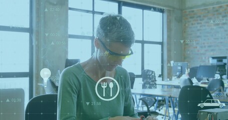Examining technician wearing goggles checking electronic parts in loft, with data overlays