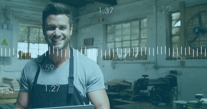 Woodworker wearing apron holding laptop showing digital overlays near table saw in carpentry shop
