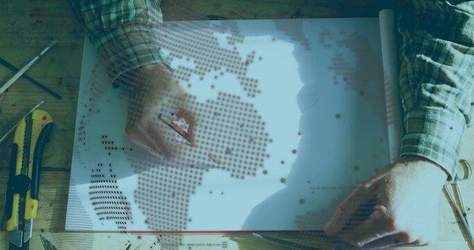Tracing woman in green checkered shirt holding pencil at workshop desk, with metal ruler, scissors