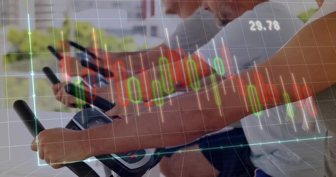 Spinning three men pedaling on spin bikes in spin studio by windows with financial chart overlay