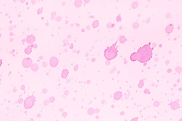 close up of pink paint splashes on canvas