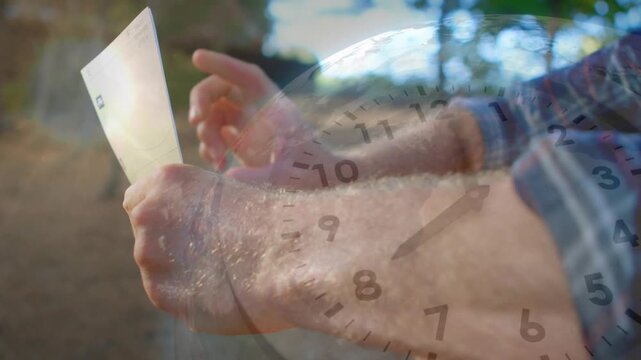 Man opening envelope in forest reading business letter for update while clock overlay tracking time
