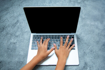 子供の手がノートパソコンのキーボードを操作する様子