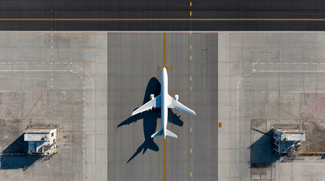 Airplane on airport tarmac top view shadow visible runway taxiway
