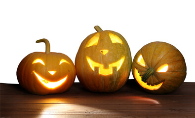 Three Halloween pumpkins on wooden table isolated on transparent PNG background