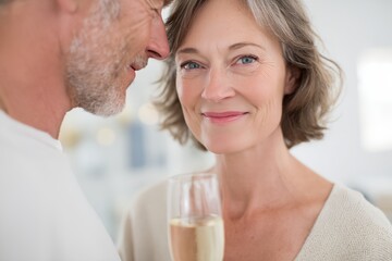 Man and a woman are kissing and holding a wine glass