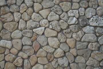 grey stone wall texture with natural round rocks – seamless background