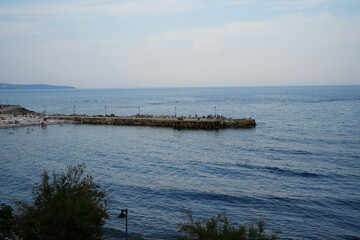 Obraz premium Stone breakwater in calm sea near Nessebar, Bulgaria. Blue water and sky creating peaceful coastal landscape with minimal composition.