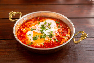 hot fresh shakshuka with garlic and herbs in a small frying pan