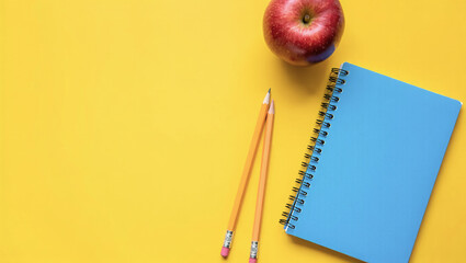Flat lay composition with a blue spiral notebook, two yellow pencils, and a red apple on a bright yellow background. Minimalist school and education concept, perfect for back-to-school themes.