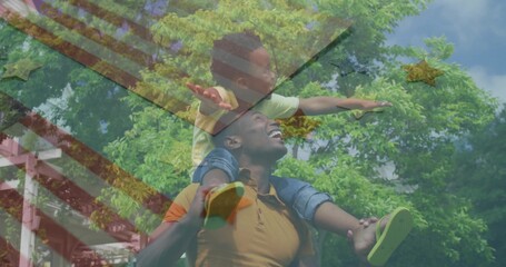 Dad in orange polo carrying son on shoulders in park, with climbing structure, green slip-on shoes