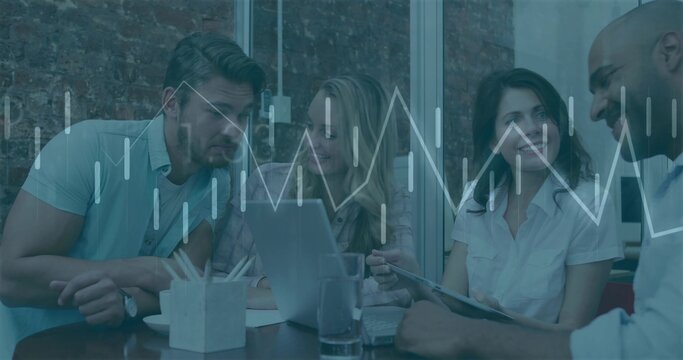 Analyzing chart overlay, four professionals at meeting table in brick office with laptop and tablet