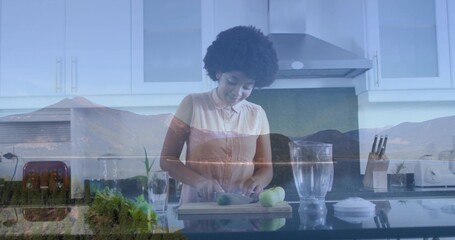 Woman wearing pink blouse chopping green apples on cutting board in home kitchen, with red toaster