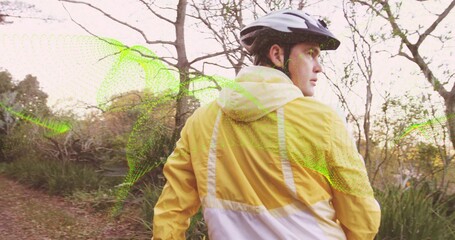 Exploring cyclist with helmet, yellow windbreaker on woodland trail, green mesh overlay, copy space