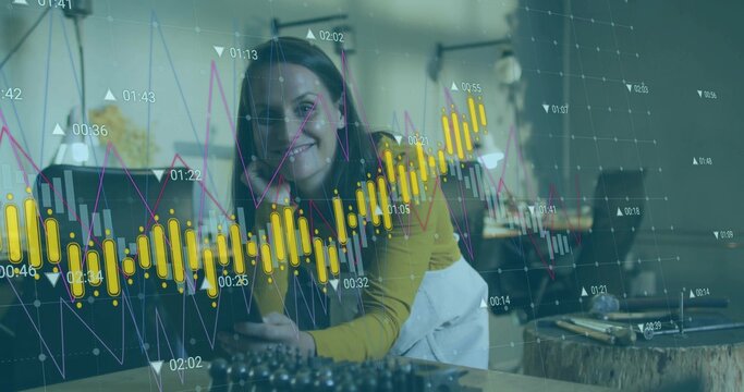 Leaning mid-adult woman wearing yellow top analyzing stock charts on smartphone at home office desk