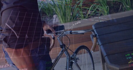 Standing man holding drop bicycle handlebars on patio by table and planters, with digital charts