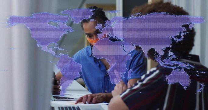 Collaborating two men working on laptops at office meeting table with mask and map overlay - Powered by Adobe