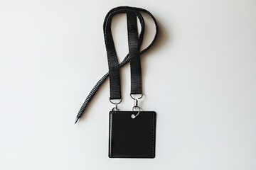 Blank black identification lanyard with a rectangular tag lies flat on a white surface.