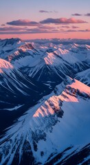 Majestic snow capped mountain peaks bathed in the soft pink and blue hues of sunrise