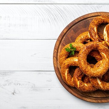 Rustikales Holzbrett mit einem Teller Simit (Sesamkringel)