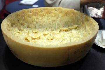 queso parmesano abierto y trozos de queso para degustar como pinchos