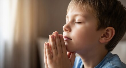 Boy with closed eyes praying, symbol of innocence and hope.