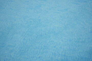 Clear blue swimming pool water with soft sunlight reflections. Minimal aquatic background — concept of freshness, purity, relaxation, and summer vacation.