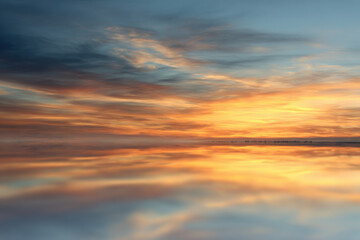 Fototapeta premium pristine floor mirror reflecting expansive sky essence of clouds at sunset