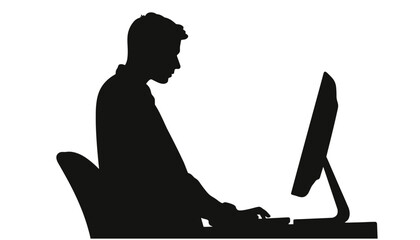 Silhouette of man typing on computer at desk in office  