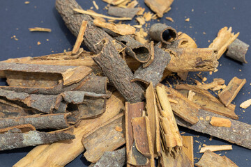 Pile of cinnamon sticks with rich textures on a dark background with copy space