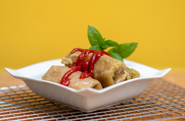 A traditional Polish dish, cabbage rolls in tomato sauce. Cabbage rolls on a yellow background.