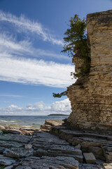 Flowerpot Island's rugged cliffs rise majestically, framed by the serene waters of Georgian Bay and a vibrant blue sky.