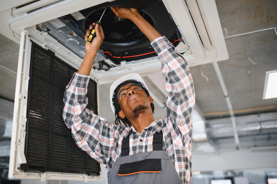 Skilled technician repairing air conditioning unit