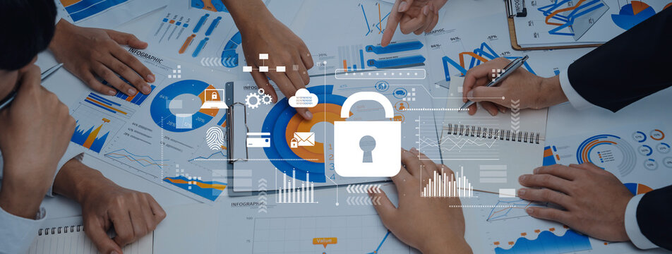 A diverse business team is engaged in a collaborative meeting, analyzing data charts and discussing security strategies displayed on the office table. Trope - Powered by Adobe
