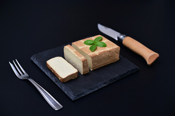 still life with vegan tofu cheese on black background