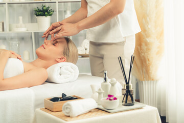 Obraz premium Caucasian woman enjoying relaxing anti-stress head massage and pampering facial beauty skin recreation leisure in dayspa modern light ambient at luxury resort or hotel spa salon. Quiescent