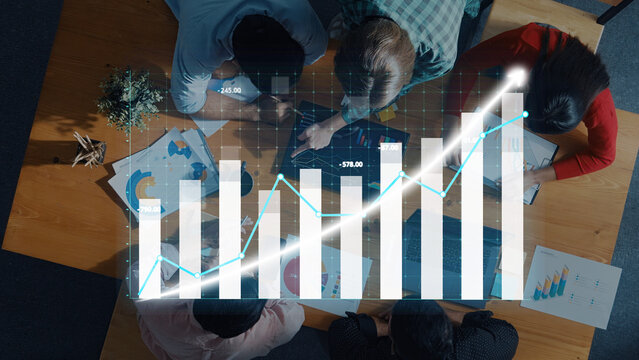 A dynamic business team collaborates in a modern office, analyzing growth charts and visual data to drive strategic decisions and enhance performance. Axiom