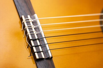 Close-up of newly replaced and taut strings on a classical six-string guitar