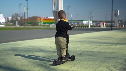 A Happy Child Riding a Bright Scooter in the Open Park, Enjoying an Adventurous Day