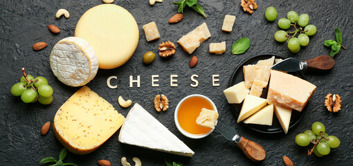 Word CHEESE and different tasty products on dark background