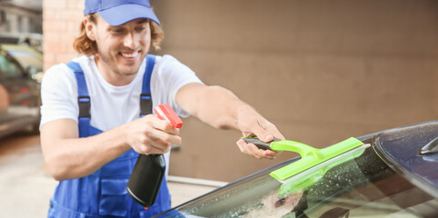Male worker tinting car window outdoors