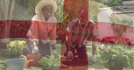 Planting seedlings man and woman kneeling in suburban garden with plastic pots watering can gloves © vectorfusionart
