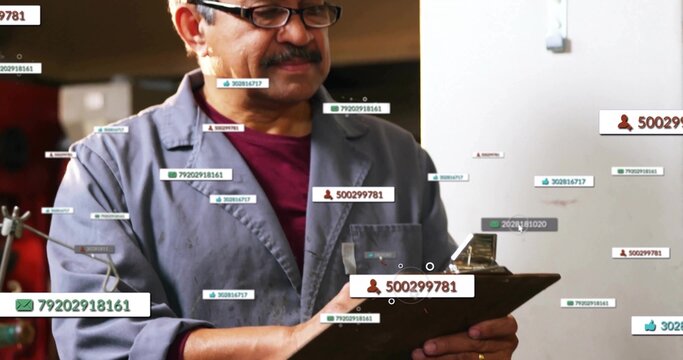 Examining clipboard, technician wearing gray jacket and red shirt in workshop with digital labels