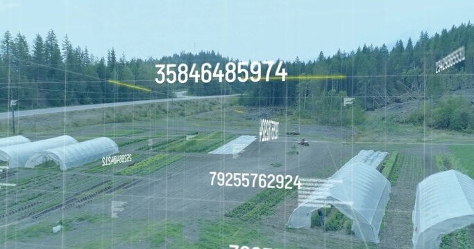 Monitoring field with tractor tilling crop rows, with hoop houses, digital grid overlay and numbers