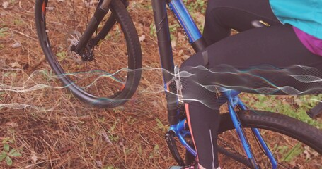 Adult cyclist riding on forest trail in tight athletic wear, with blue bicycle and waveform overlay