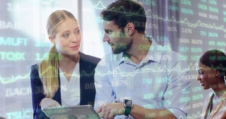 Reviewing three colleagues analyzing stock data in office boardroom, with laptop and chart overlay