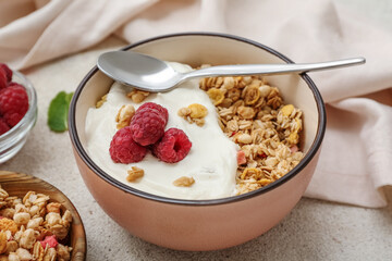 Bowl of tasty granola with yogurt and berries on grunge background, closeup