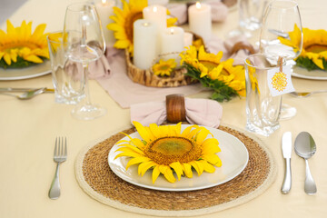 Paper with flower attached to glass and dinnerware with sunflowers in room