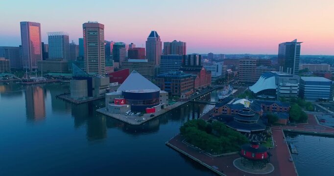 Aerial view of Baltimore's Inner Harbor at dusk in Maryland, USA. The photo captures the city skyline, waterfront, and harbor landmarks. Showcases urban beauty.